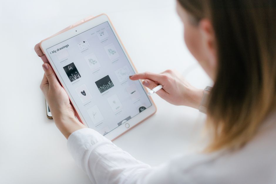 A woman interacts with a tablet to create digital art. Ideal for technology and creativity