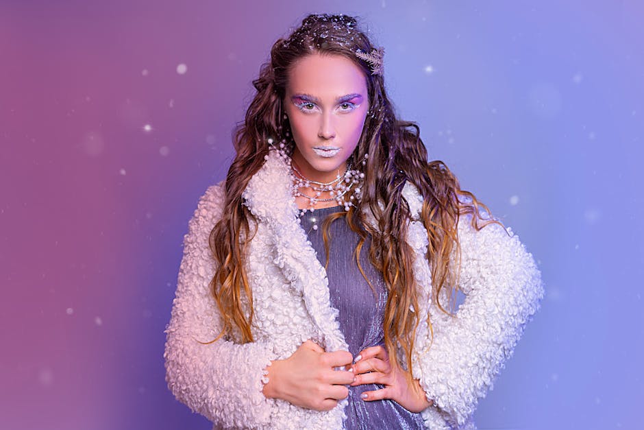 Artistic portrait of a woman in winter fashion, featuring snowy makeup and a stylish coat.
