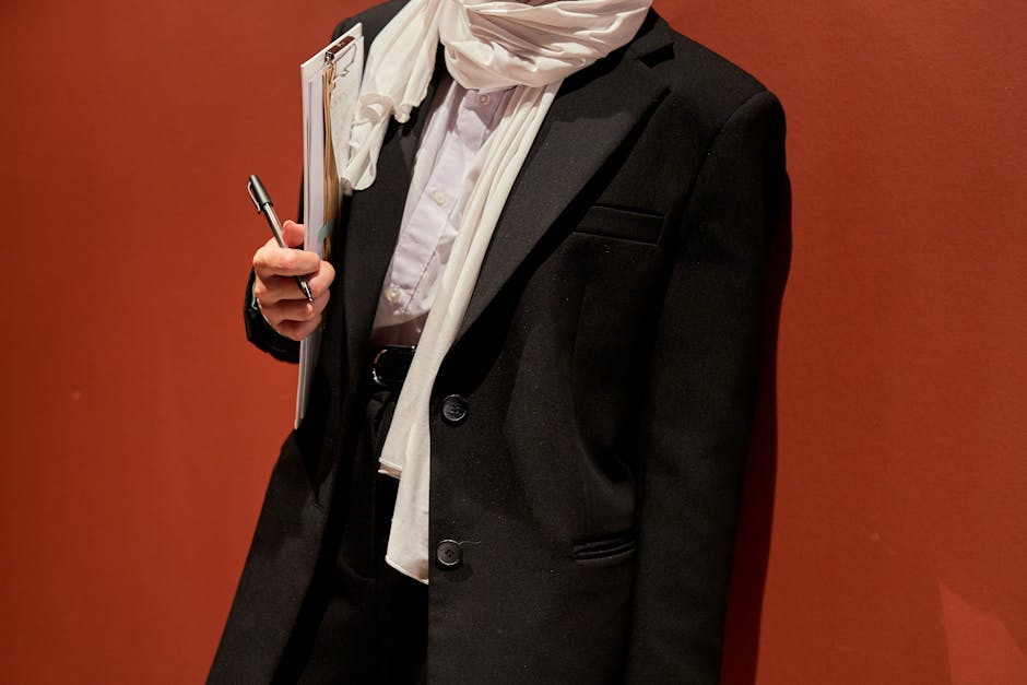 Businesswoman in formal attire and hijab holding documents during a professional event.
