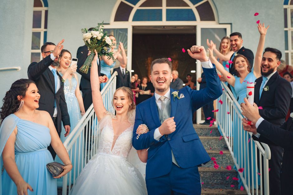 Newlyweds celebrate with friends and family after their wedding ceremony, surrounded by joy and confetti.