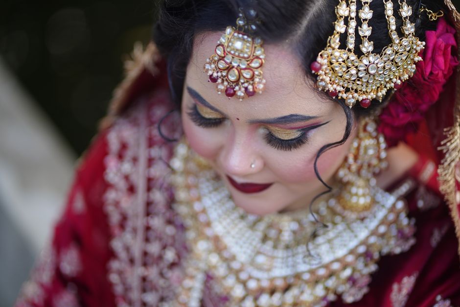 A beautiful bride elegantly adorned in traditional jewelry and makeup captures a stunning cultural moment.