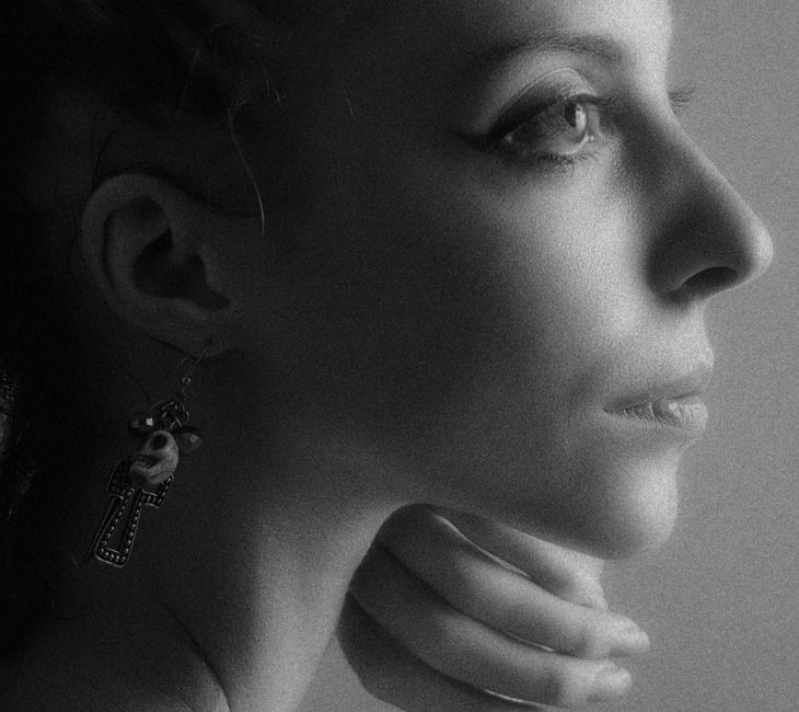A captivating black and white close-up of a young woman with elegant earrings in a subtle side view.