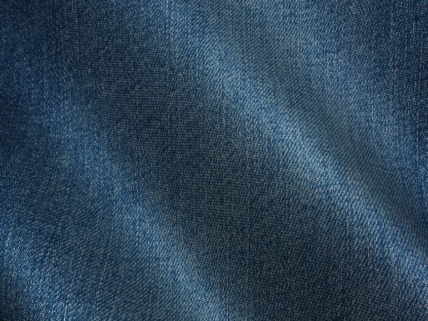 Detailed image of blue denim fabric showing texture and weave pattern.