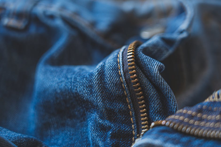 Detailed close-up of a blue denim jeans zipper with a soft focus.